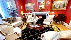 A room with a fireplace, two armchairs, a sofa, and a coffee table. - Charlotte's Rose Inn (Charlottetown)