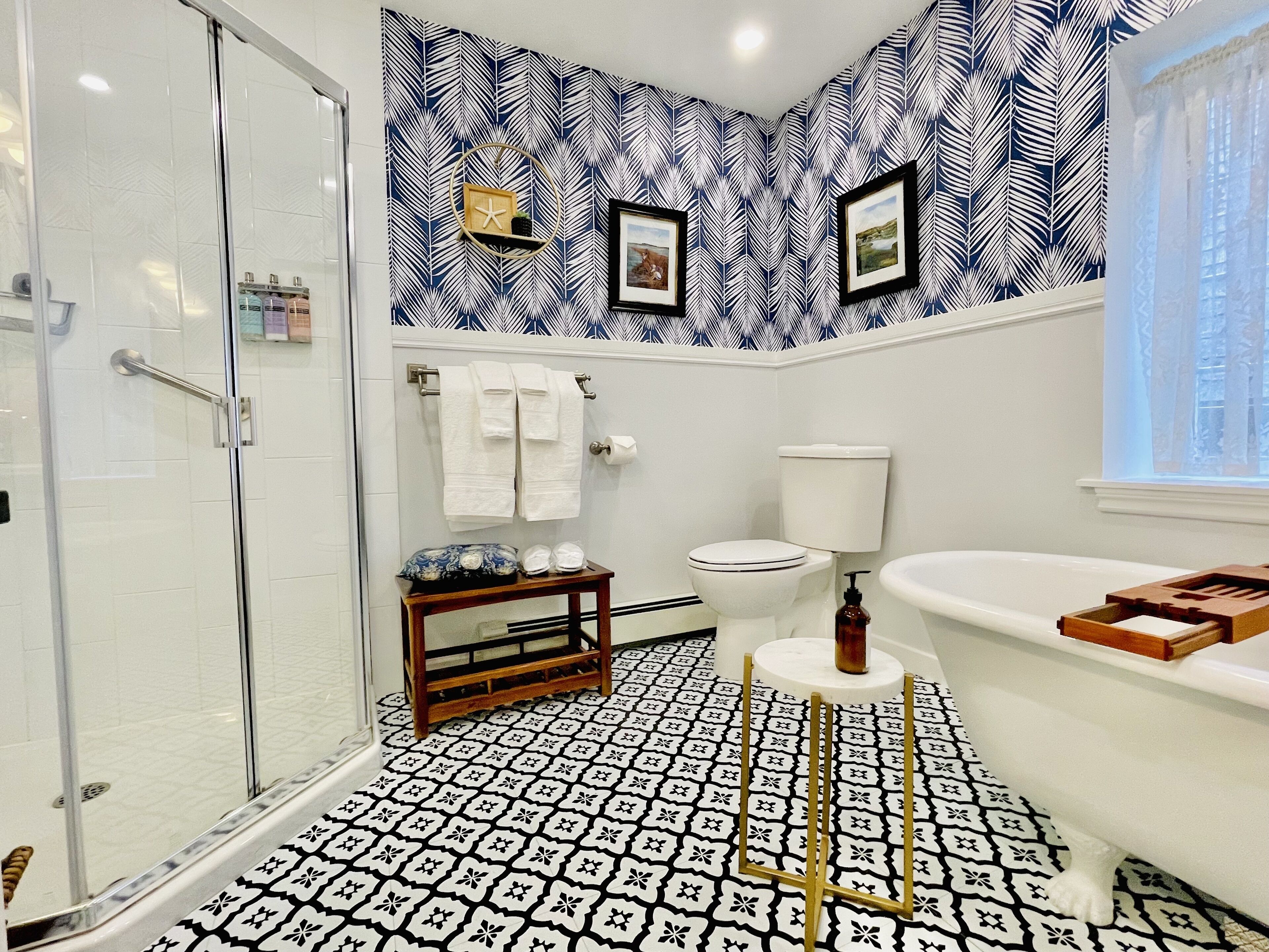 A bathroom with a patterned floor, a toilet, a sink, and a shower area.