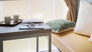 A room with a window, a table with cups and glasses, a pillow, and a bed. - Coco Sweet 1 - Coco Sweet tents on the beach (Lychen)