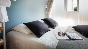 A bedroom with a bed, pillows, a magazine, and a pair of glasses on the bed. - Coco Sweet 1 - Coco Sweet tents on the beach (Lychen)