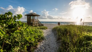 A wooden beach hut with a staircase leading to a deck overlooking the ocean. - Courtyard by Marriott Delray Beach (Delray Beach)