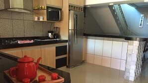 Una cocina moderna con un refrigerador de acero inoxidable, un microondas y una encimera negra.