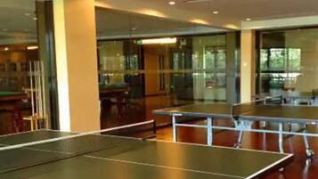 A room with ping pong tables and glass walls.