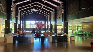 A spacious lobby with a high ceiling, large windows, and a central seating area. - Amanda Seaview Resort Apartment (Lingshui)