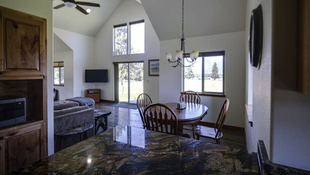 A spacious kitchen with a large island, a dining area with a round table, and a cozy seating area with a sofa. - Bitterroot Oasis (Stevensville)