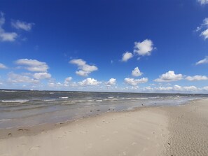A beach with a clear sky and waves.