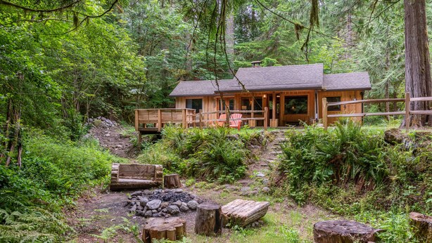 A cabin with a deck and a fire pit surrounded by natural forest. - Cozy cabin in the Woods, Hot tub, secluded, walk to ZigZag River ! (Rhododendron)