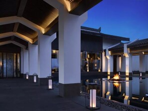 Un edificio moderno con patio central, con una chimenea y faroles.