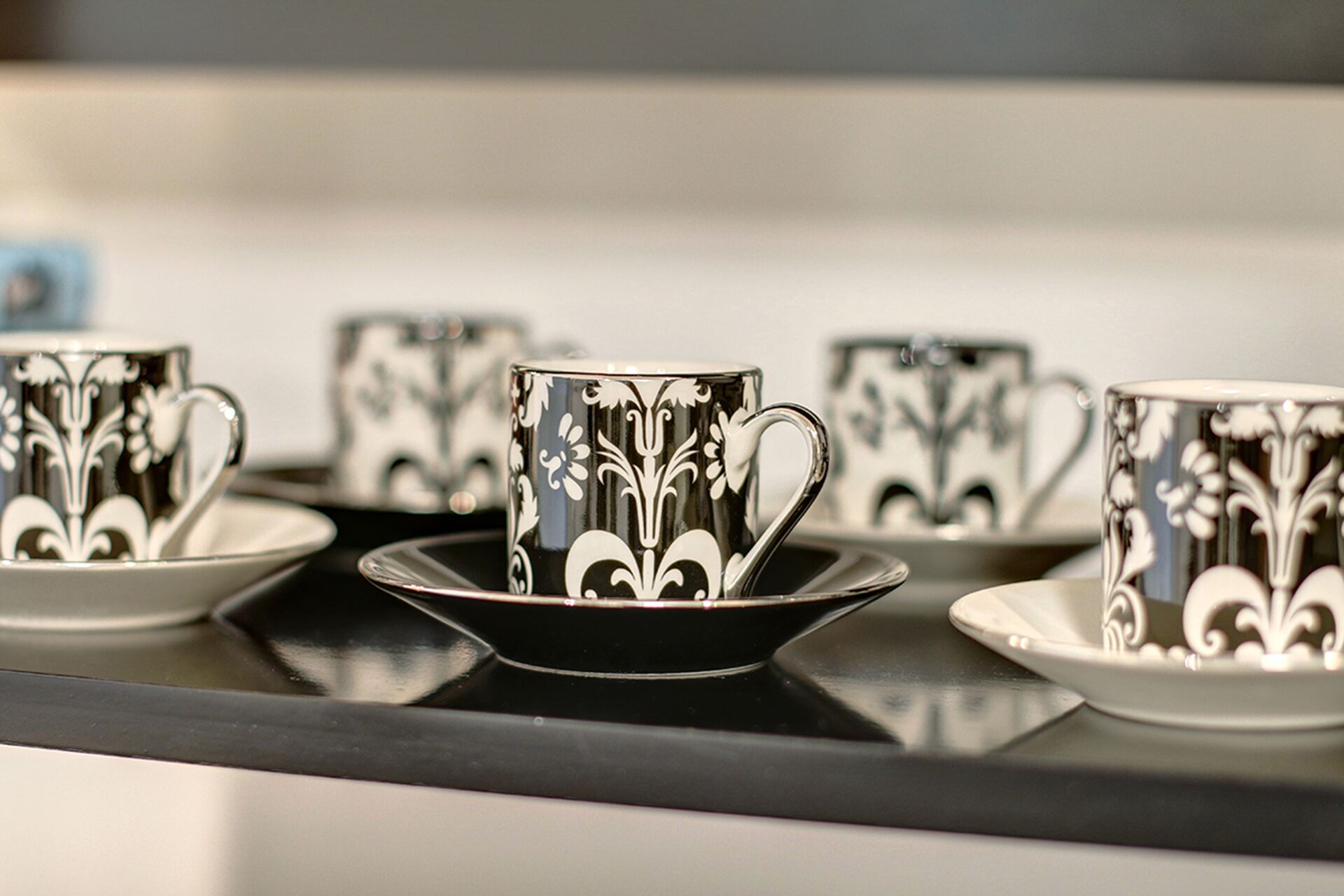 A row of black and white patterned cups on a tray.