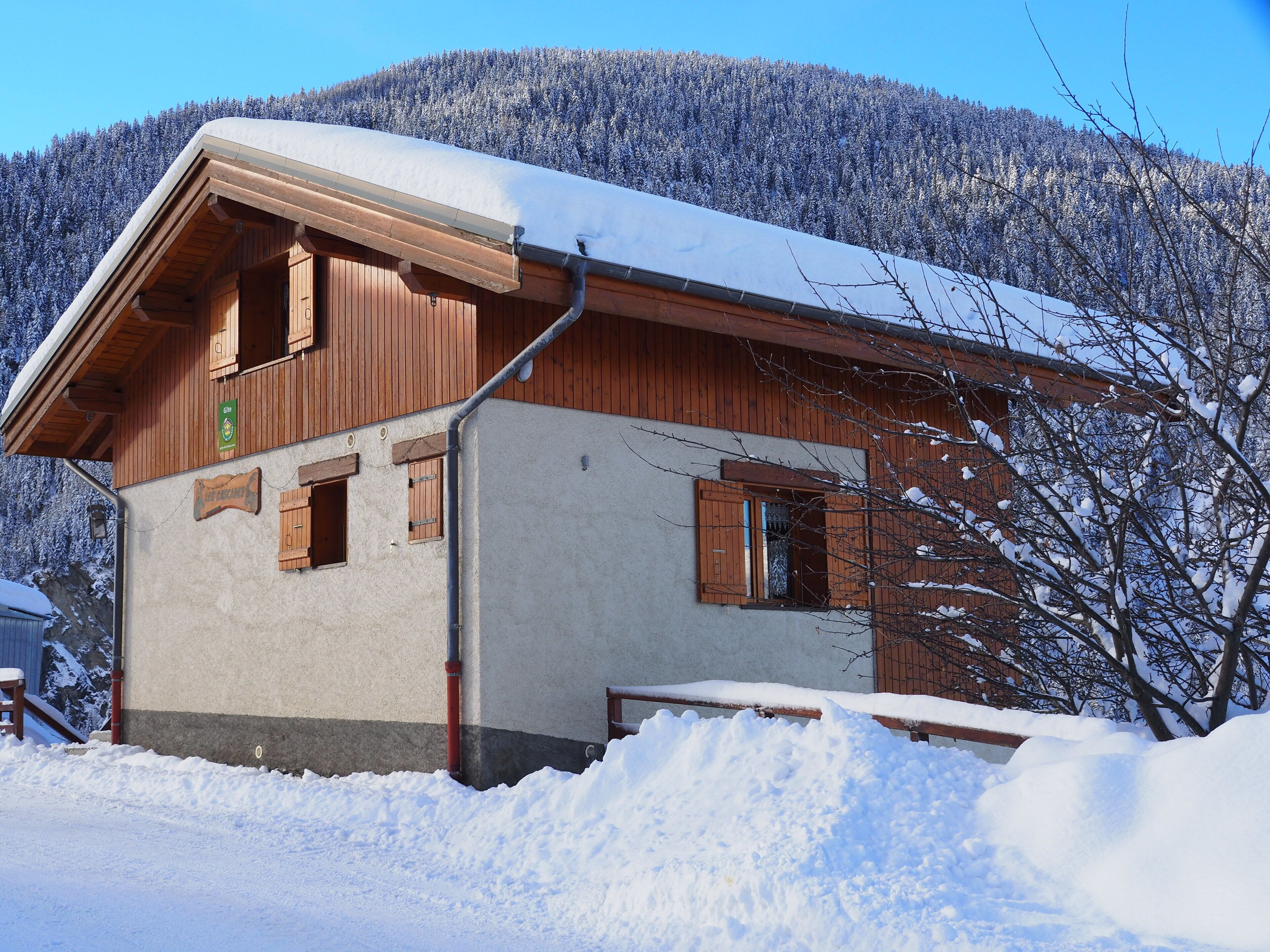 En chalet i trä med ett sluttande tak, träpersienner och en skylt som visar att det är en restaurang.