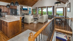 A spacious kitchen with wooden cabinets, a granite countertop, and a dining area with a view. - Upscale Home near Blue Ridge Parkway (Boone)