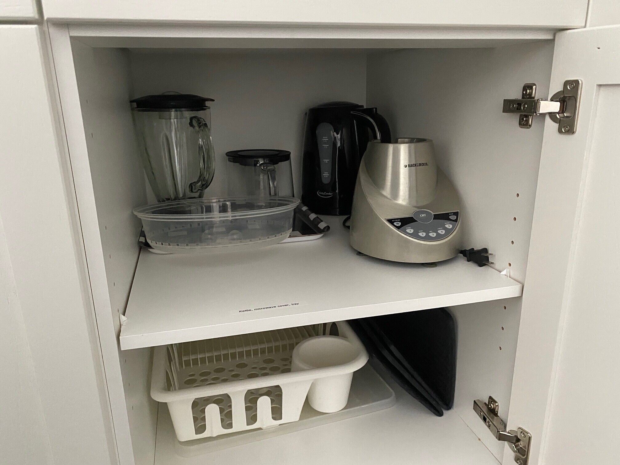 Eine Küche mit Wasserkocher, Kaffeemaschine, Mixer und Mikrowelle.