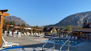 Un espace piscine avec des chaises longues et une vue sur les montagnes.
