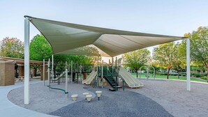 Une aire de jeux avec des toboggans, des structures d’escalade et un espace ombragé.