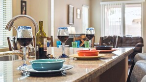 Un comptoir de cuisine avec des verres à vin, des bouteilles et de la vaisselle.