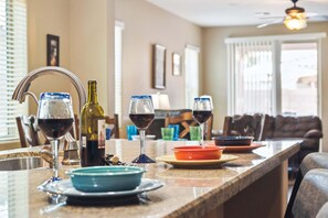 A kitchen counter with wine glasses, bottles, and dishes. - MONTHLY SPECIAL Patrick Place Spacious 3 BR Home Golf/Shopping/Gilbert (Gilbert)