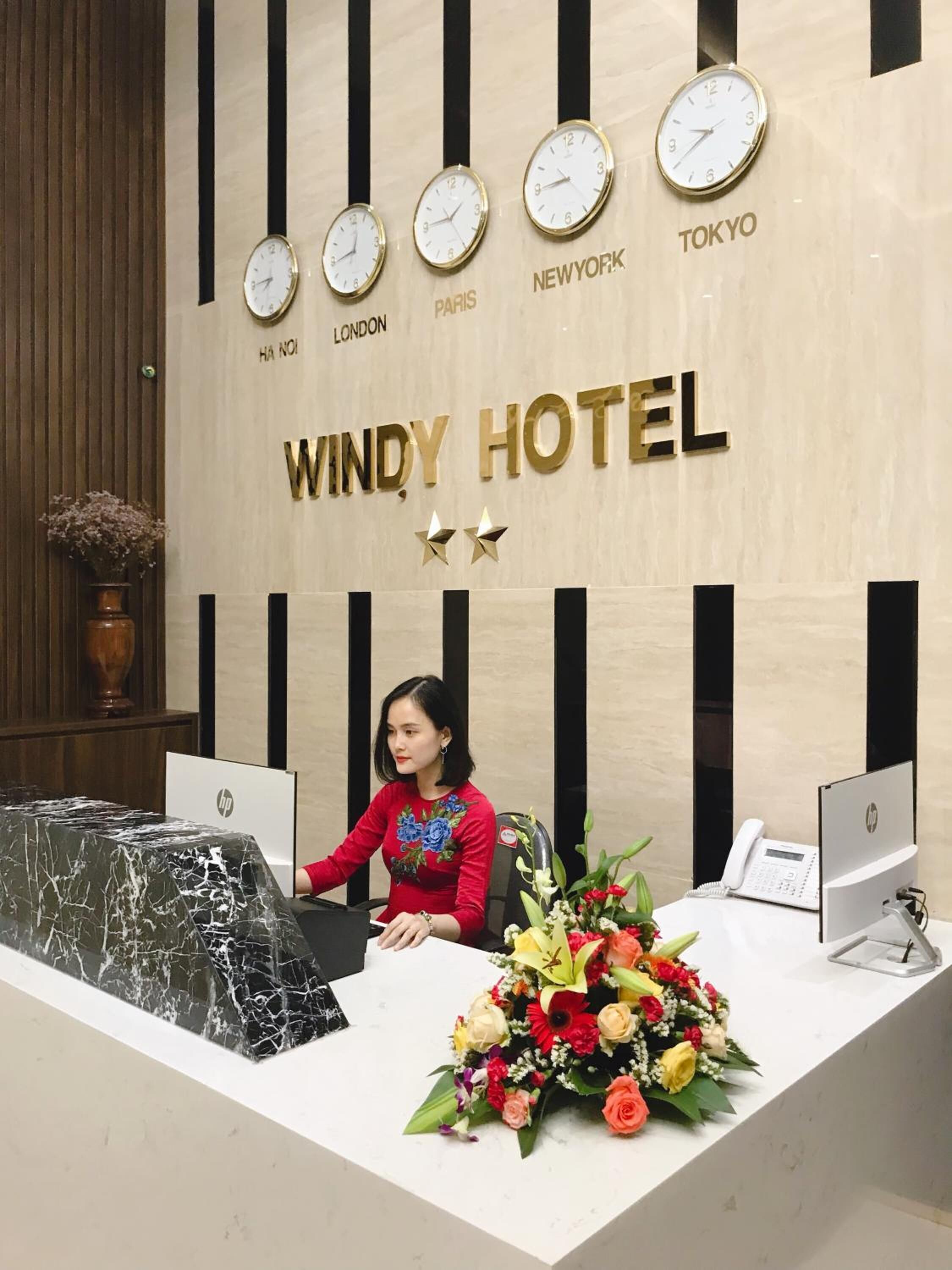 Eine Rezeption im Windy Hotel mit Uhren, die die Zeiten für New York, Paris, London und Tokio anzeigen.