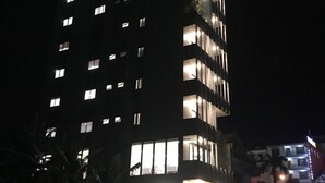 A tall hotel building with illuminated windows and a sign that reads "WINDY HOTEL".