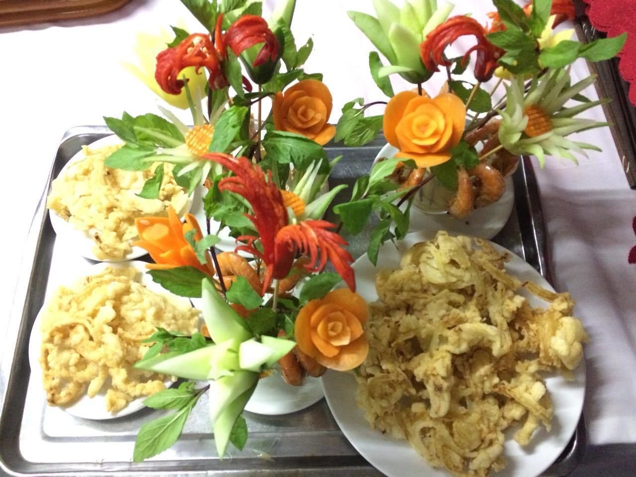 A tray with three plates of food, each with a decorative arrangement of vegetables and flowers.
