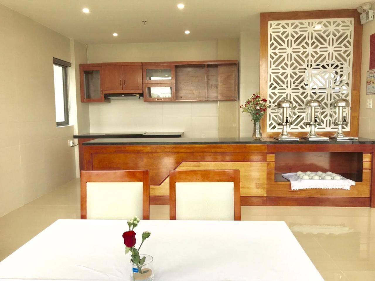 Una cocina moderna con armarios de madera, una isla central y un separador decorativo.