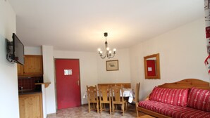 Un espacio habitable compacto con comedor, sofá y cocina.