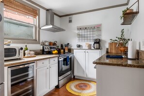 Una cocina moderna con electrodomésticos integrados, un calendario y una tabla de cortar de madera.