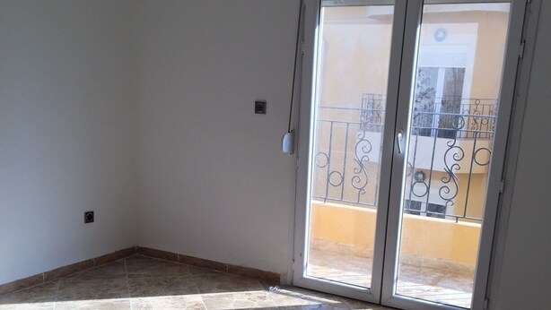 A room with a tiled floor, a sliding glass door leading to a balcony, and a small window. - Apartment in a private residence with caretaker (Souidania)