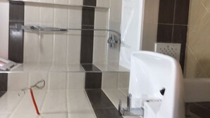 A bathroom with a glass shower enclosure, a white toilet, and a tiled floor with black and white tiles. - Apartment in a private residence with caretaker (Souidania)
