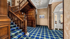 A grand staircase with wooden railings and blue plaid carpet. - Victorian Mansion, fully refurbished, sleeps 24 guests in 12  ensuite bedrooms (Carnoustie)