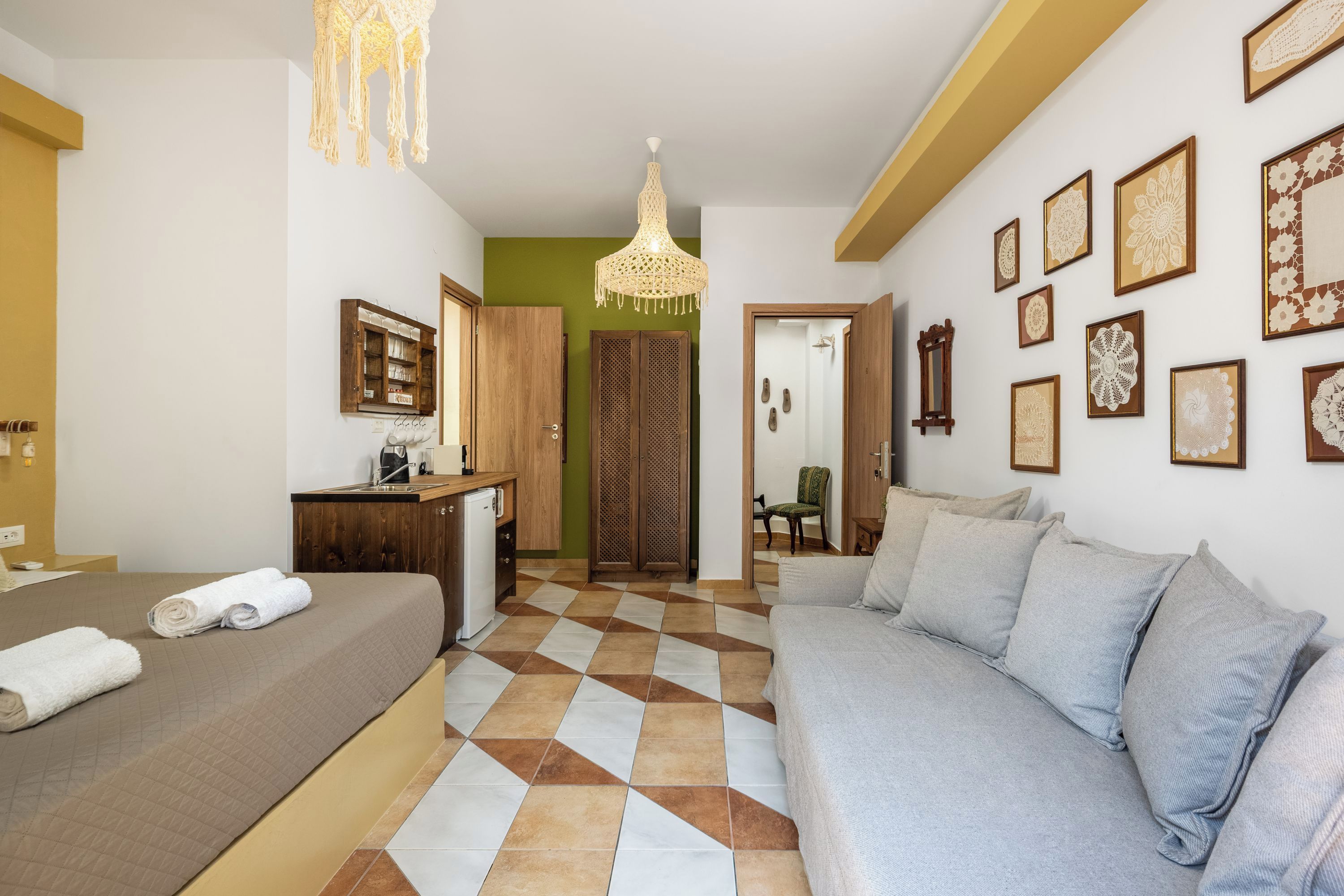 Ein Hotelzimmer mit Bett, Sofa, Schreibtisch und einer Chandelier.