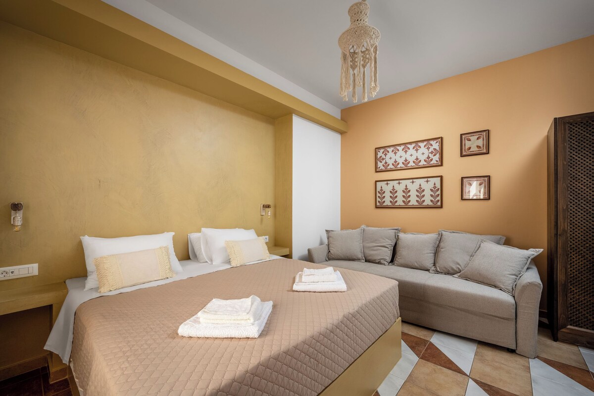 Une chambre d’hôtel avec un grand lit, un canapé et un mur décoré de motifs.
