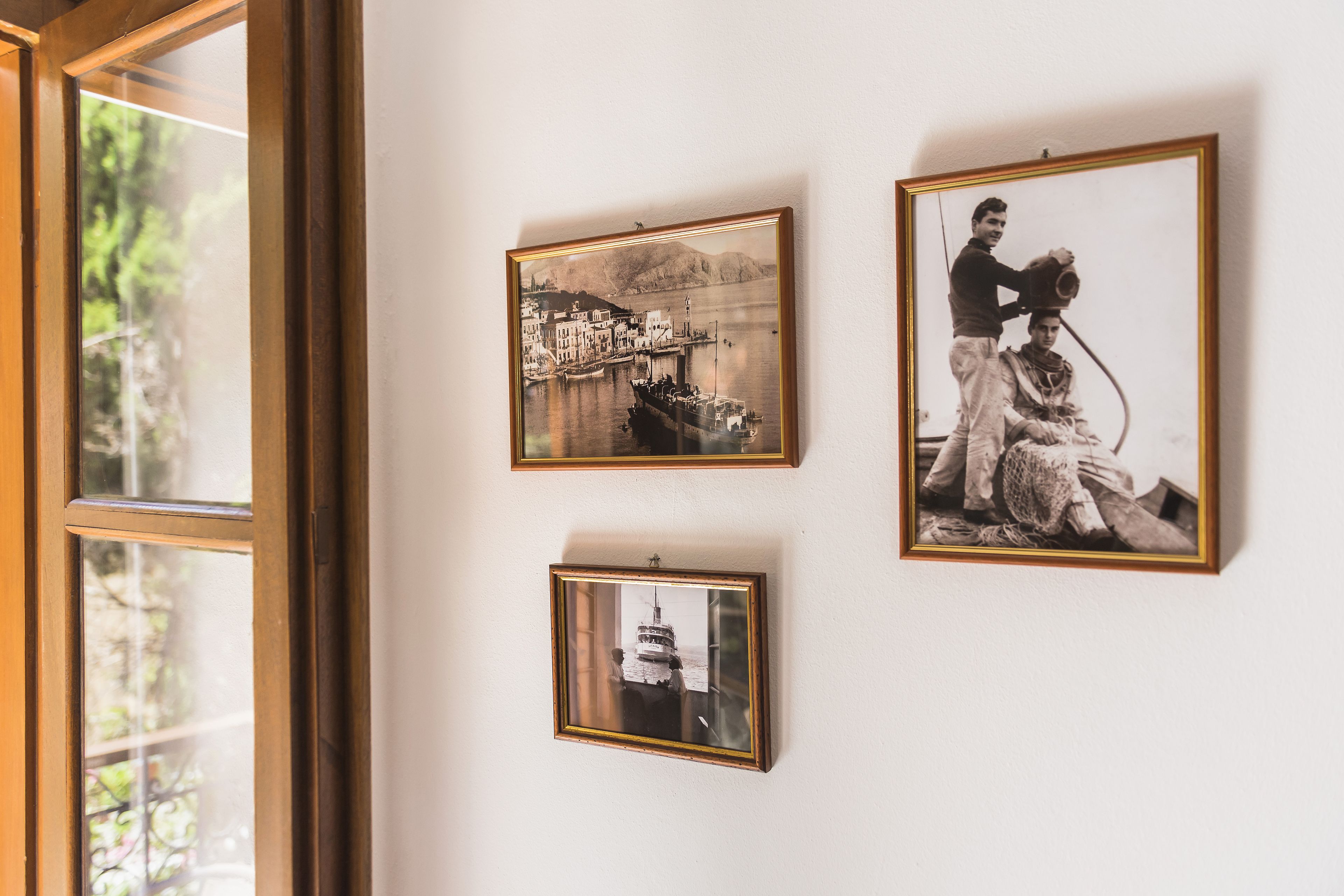 Drie ingelijste foto's aan een muur.