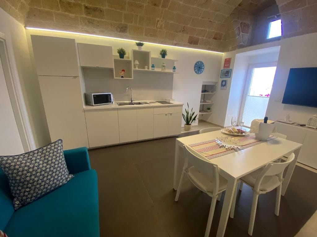 A compact living space with a kitchenette, dining area, and a sofa.
