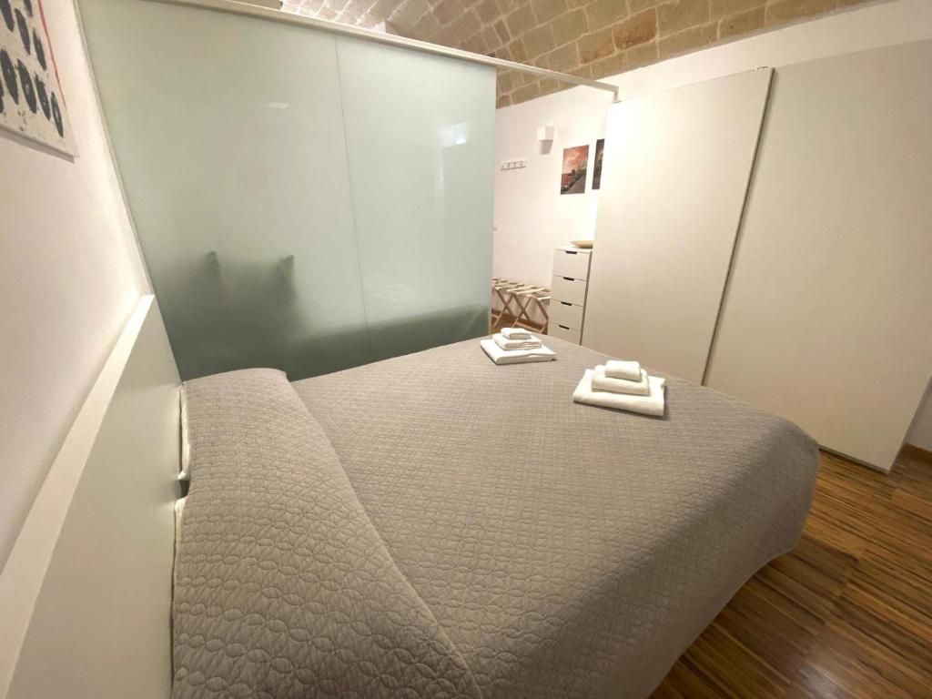 A bedroom with a bed, a nightstand, and a wardrobe.