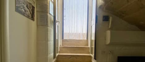 A staircase leading to a landing with a television and a small table.