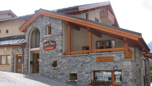 Un bâtiment en pierre sur lequel on peut lire l’inscription : « Destination Haute-Maurienne Les Essarts ».