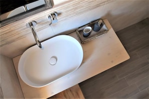 A modern bathroom with a white sink, a mirror, and a tray with two cups. - B&B Torre Castellina (Piazza Armerina)