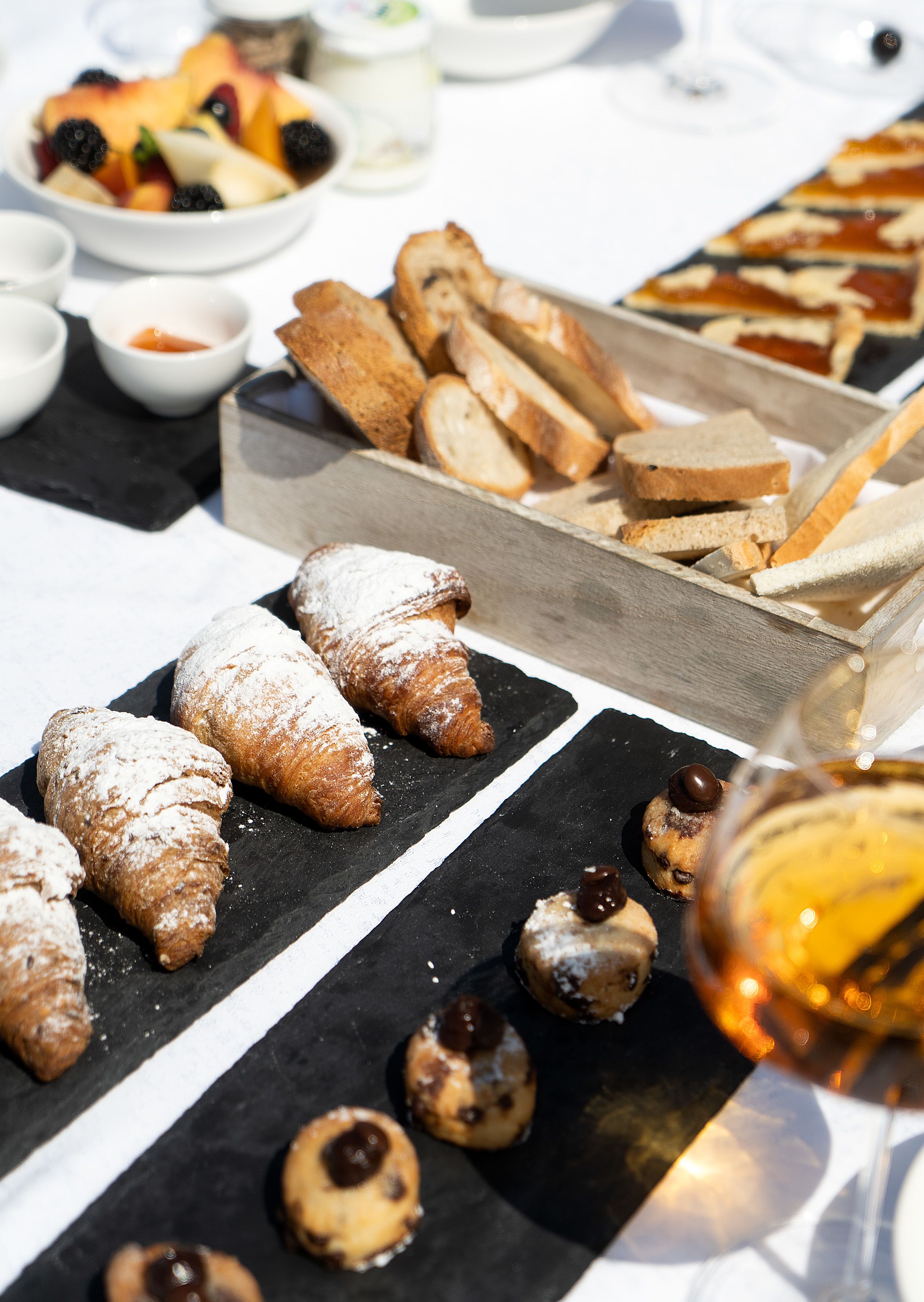 Verschiedene Backwaren und Brot auf einem Tisch, darunter Croissants und kleine Schokoladenspezialitäten.