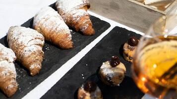 Verschiedene Backwaren und Brot auf einem Tisch, darunter Croissants und kleine Schokoladenspezialitäten.