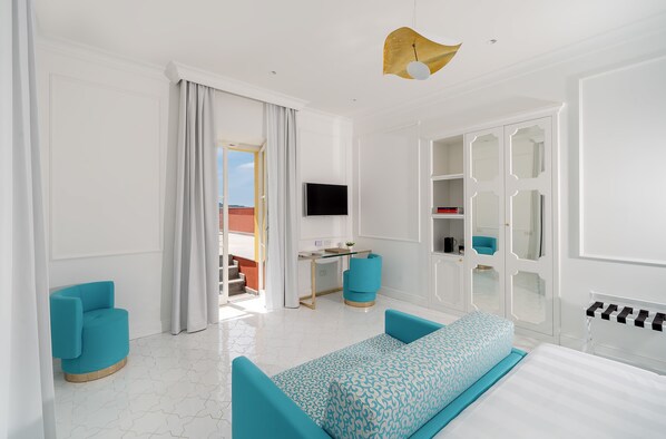 A modern hotel room with a bed, a desk, a TV, and a view of the outdoors. - Hotel Lorelei Londres (Sorrento)