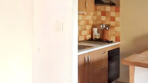 Une cuisine avec des meubles de rangement en bois, un évier et un plan de travail.