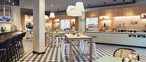 Un restaurant moderne avec un sol à carreaux, de nombreuses tables et des lampes suspendues.