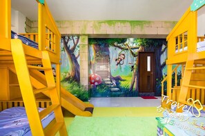 A children's room with bunk beds, a slide, and a mural of a forest scene. - J.S 23 Kids Homestay (Kaohsiung)