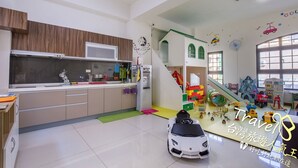 A modern kitchen with a built-in microwave, a sink, and a window above the counter. - J.S 23 Kids Homestay (Kaohsiung)