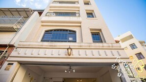 A tall, beige building with multiple windows and balconies. - J.S 23 Kids Homestay (Kaohsiung)