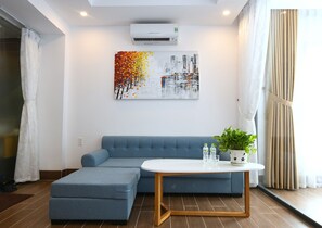 Apartament Deluxe, cuina bàsica | Sala d'estar | Televisor de pantalla plana de 23 polzades amb canals per cable 