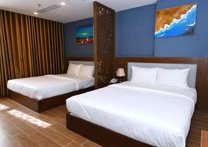 Two single beds with wooden headboards, a decorative partition, and artwork on the walls.