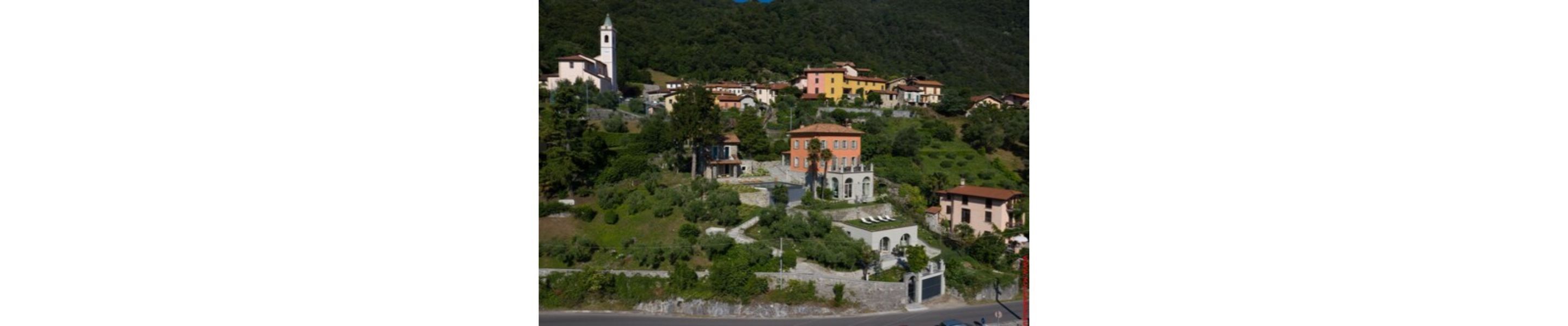 A hillside village with traditional buildings, a church, and a small tower.