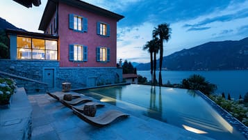 Una piscina al aire libre de temporada, sillones reclinables de piscina