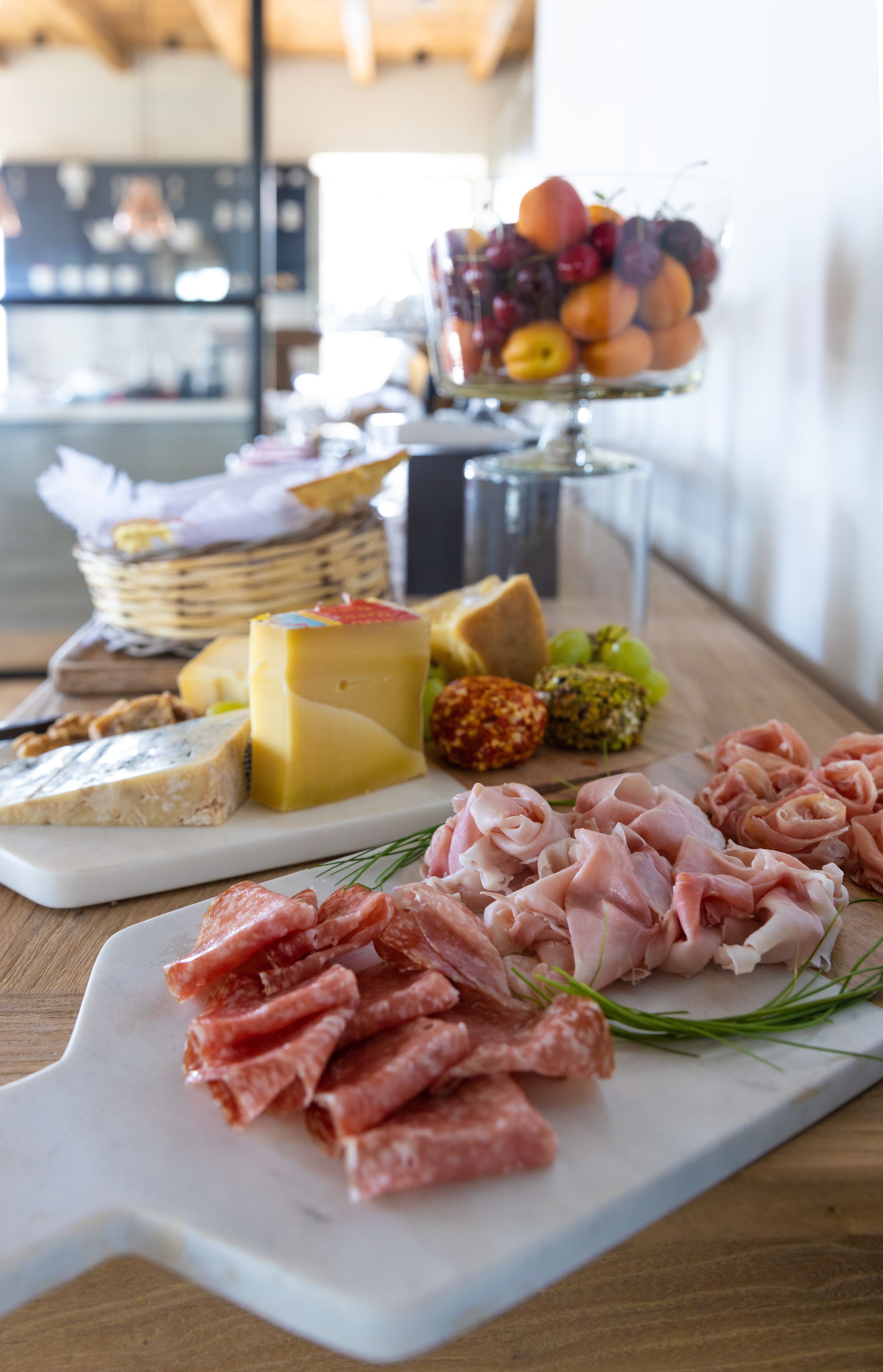 A charcuterie board with various meats, cheeses, and fruits.